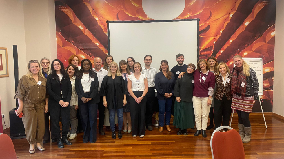A group of people standing together and smiling at the camera
