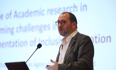 João Costa standing at a podium and speaking into a microphone