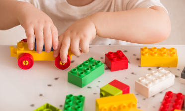 A child's hands, playing with colourful building blocks